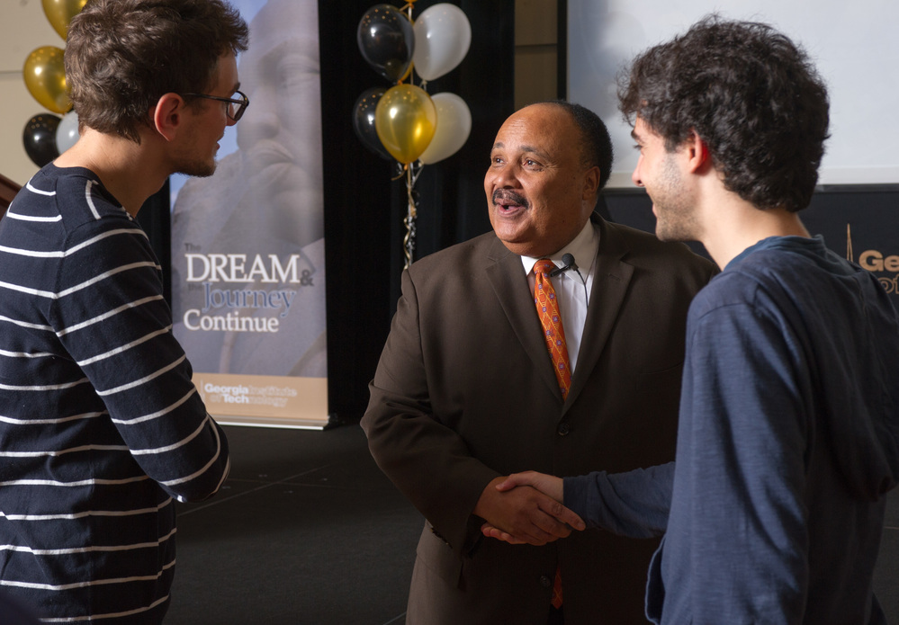 two students speaking to an older black gentleman