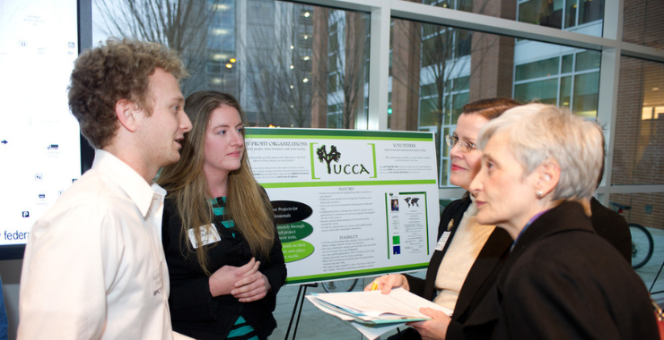 students speaking with alumni (4 people)