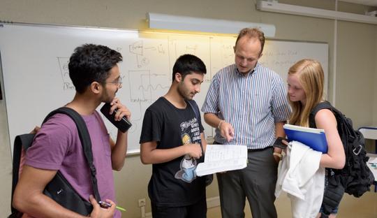 Students standing with a professor