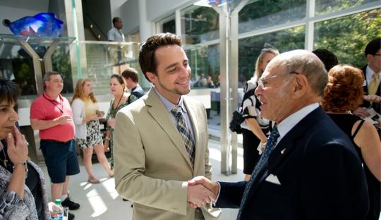 Two men shaking hands at event