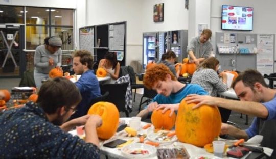 students carving pumpkins