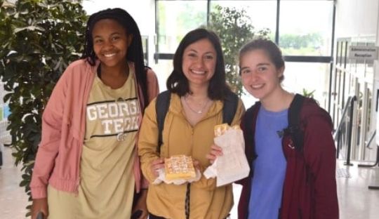 Three students smiling at the camera