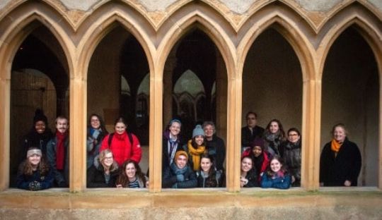 Students standing in the arches of historic building