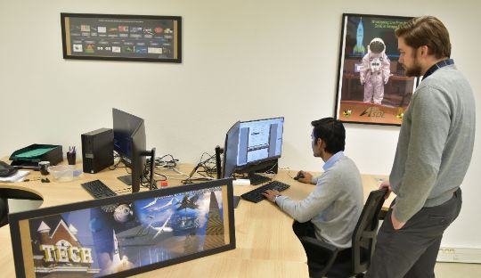 STUDENTS LOOKING AT COMPUTER