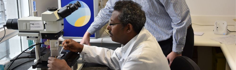 Man in lab coat looking at a machine