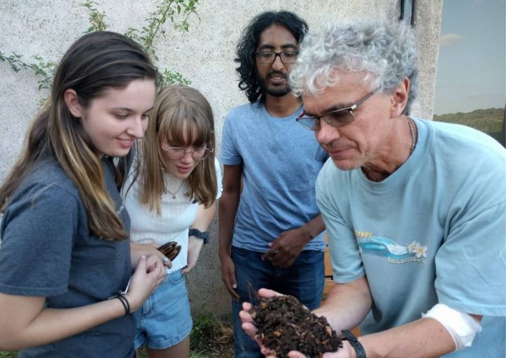 Teacher holding soil out to students to see