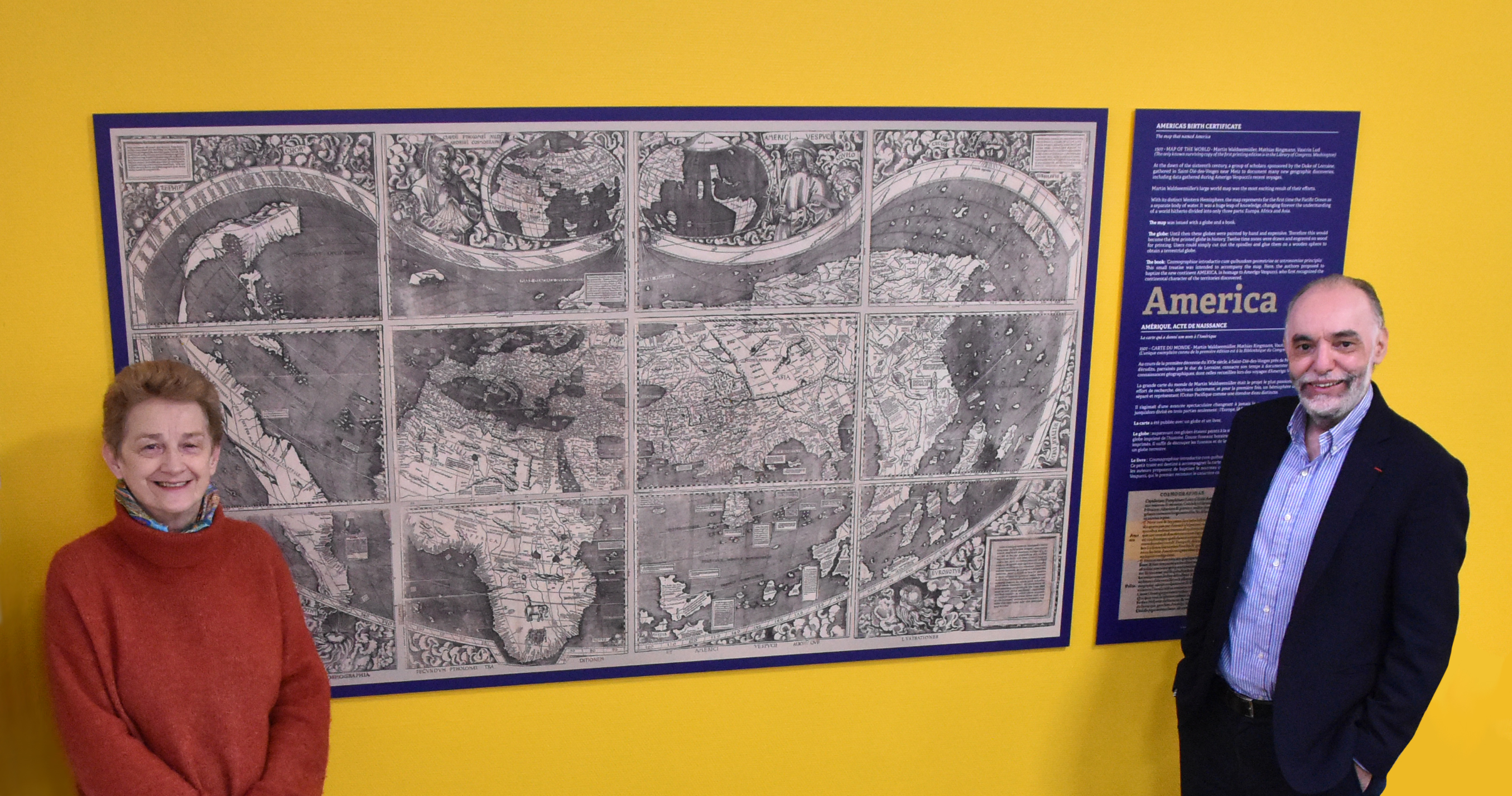 Sonia Serafin and Abdallah Ougazzaden pose by a copy of the famous world map by Martin Waldseemüller, hanging in Georgia Tech-Lorraine's student lounge.