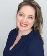 Photo of woman with light brown hair and blue eyes in navy shirt